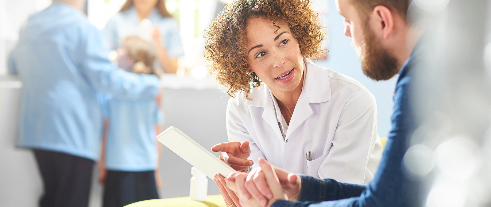 Doctor smiling with patient as she holds document in front of them